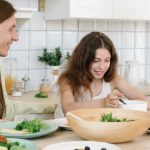 Father and daughter sharing a joyful breakfast at home in the kitchen.